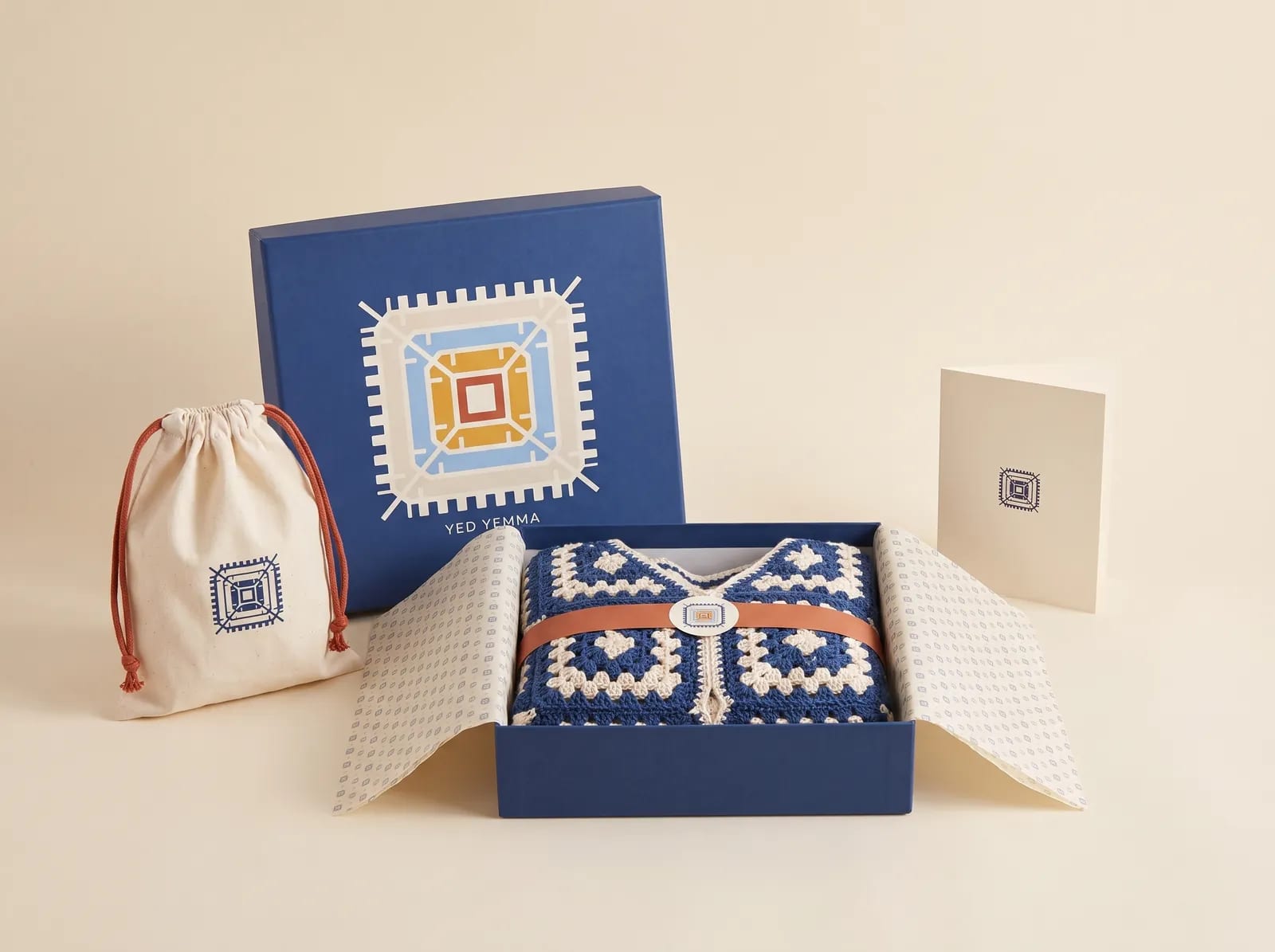 Le packaging Yed Yemma : pochette en coton et boîte indigo marquées de l'icône